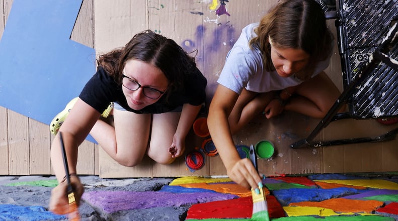 Onica Zecher, 16, left, and Gianna Frongia, 18, paint the exterior of the Art Central Foundation building on Main Street in Middletown in June 2024. NICK GRAHAM/STAFF