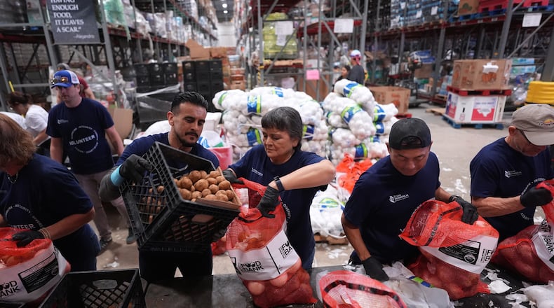 Volunteers at the San Antonio Food Bank load bags of potatoes for a food distribution for SNAP recipients and other households affected by the federal shutdown, Thursday, Nov. 6, 2025, in San Antonio. (AP Photo/Eric Gay)