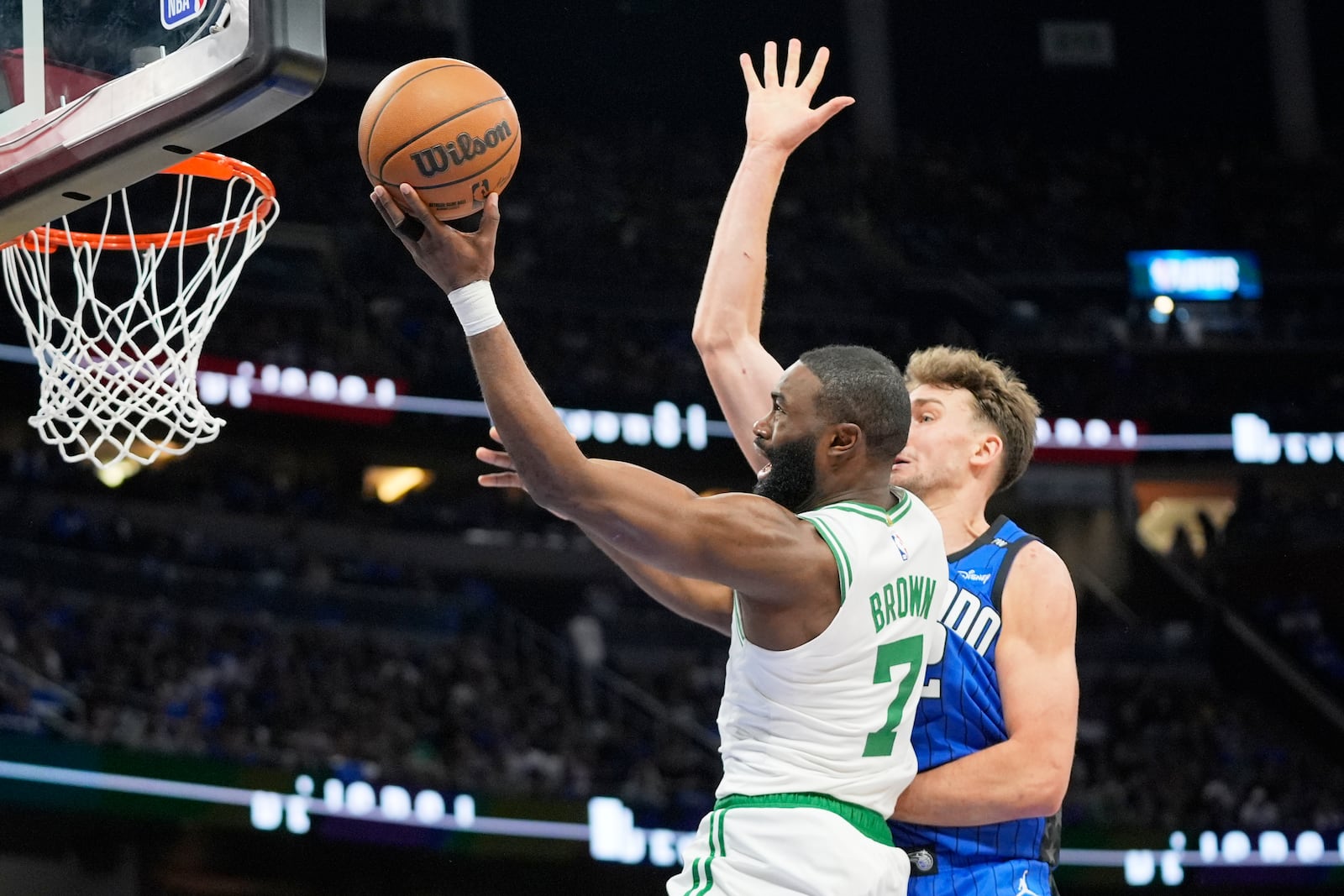 Boston Celtics guard Jaylen Brown (7) makes a shot as he gets past Orlando Magic forward Franz Wagner during the first half in game 3 of a first-round NBA playoff basketball series,, Friday, April 25, 2025, in Orlando, Fla. (AP Photo/John Raoux)