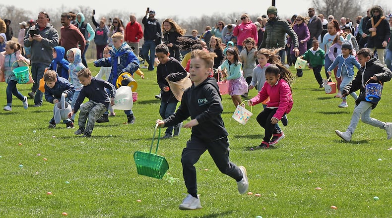 Hundreds of children race across the driving range at Young's Jersey Dairy picking up dyed hard boiled eggs during the annual Easter egg hunt Sunday. This was the 39th anniversary for the egg hunt at the dairy, however, it was the first time in two years it was held due to the COVID pandemic. This year Young's put out over 10,000 eggs for the children to collect. BILL LACKEY/STAFF