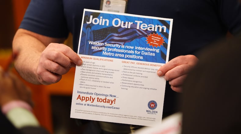 FILE - A recruiter holds information about employment during a hiring fair at Fair Park in Dallas, Jan. 14, 2026. (AP Photo/LM Otero, File)
