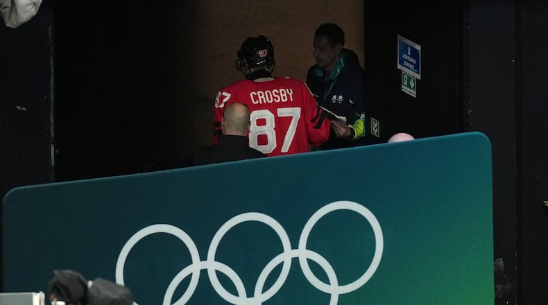 Canada's Sidney Crosby (87) is led away from the ice after being injured during the second period of a men's ice hockey quarterfinal game between Canada and Czechia at the 2026 Winter Olympics, in Milan, Italy, Wednesday, Feb. 18, 2026. (AP Photo/Hassan Ammar)