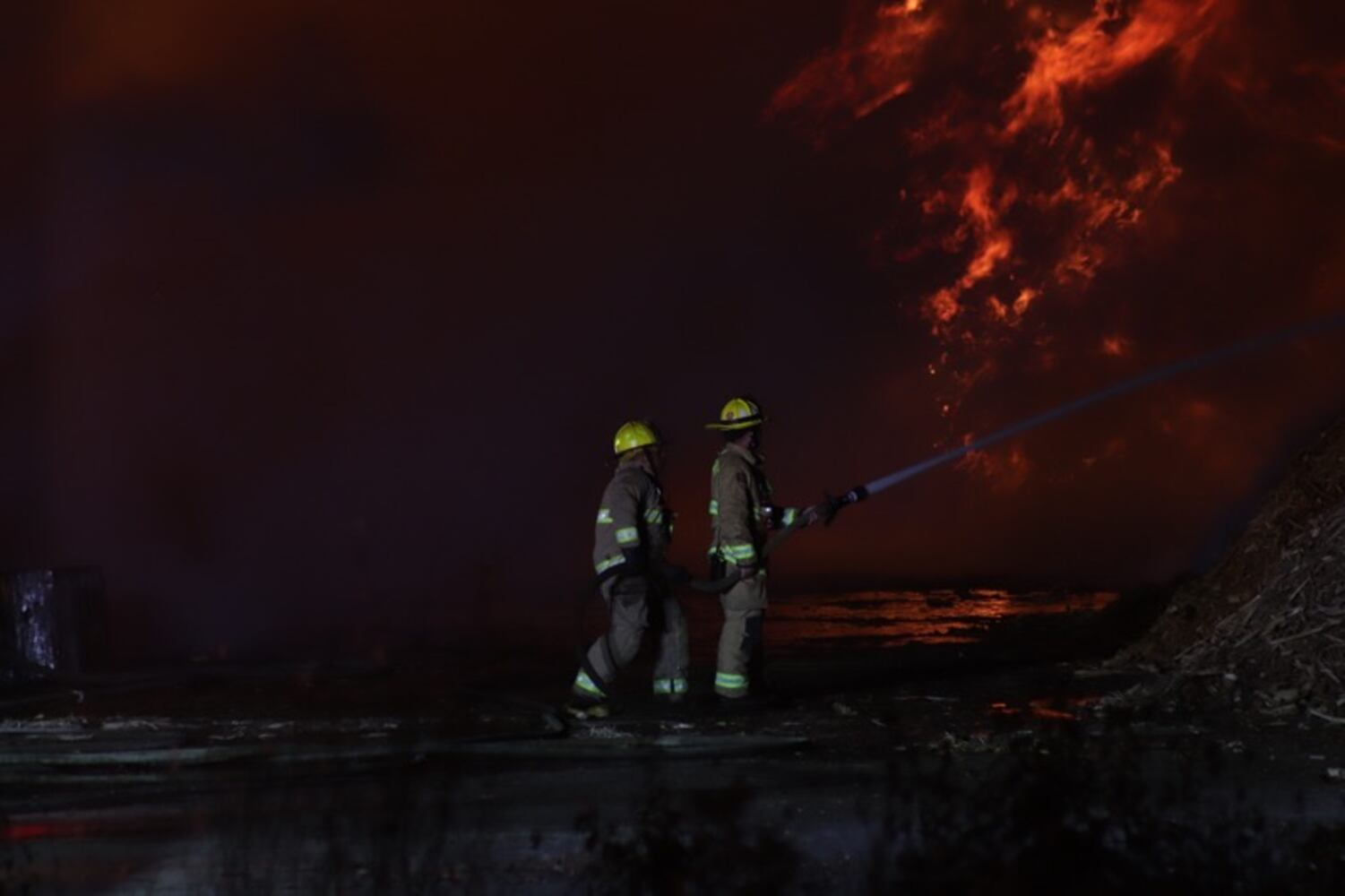Fire crews battling huge fire in wood piles on Harshman Road