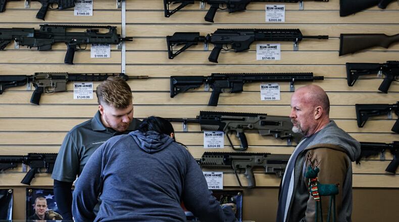 Miami Armory sale associates, Casey McKenzie, left and Dave Saxarro help a customer at the store Thursday December 7, 2023. JIM NOELKER/STAFF