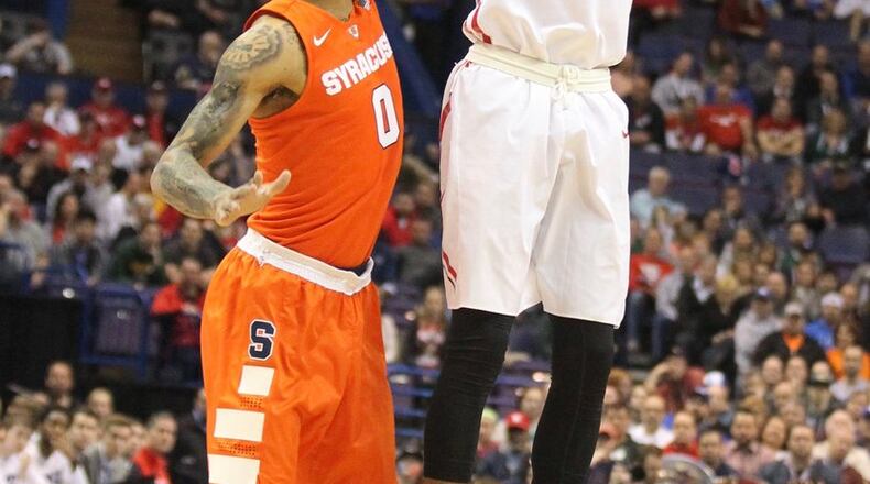 Dayton’s Charles Cooke shoots a 3-pointer against Syracuse’s Michael Gbinije in the first round of the NCAA tournament on Friday, March 18, 2016, at the Scottrade Center in St. Louis. David Jablonski/Staff