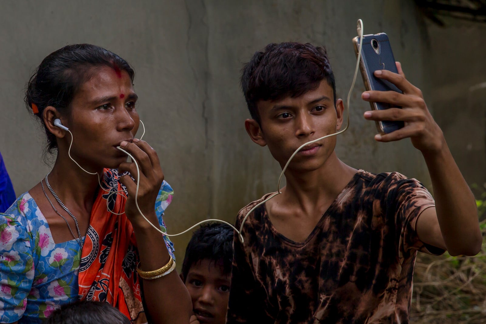 FILE - Sarasvati Devi talks to her mother in Myanmar via video call as Ranjan, her brother, holds the phone, outside a camp for Hindu refugees near Kutupalong, Bangladesh, Sept. 26, 2017. (AP Photo/Dar Yasin, File)