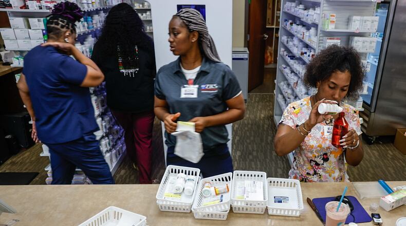 Pharmacy technicians for Ziks Pharmacy on West Third Street Jasmine Woodard, right and Joy Duaka, center, prep medications at the store on Monday, July 1, 2024. The closing of many pharmacies around Dayton is making it harder for residents to get their medications and harder for the pharmacies left to meet growing demands. JIM NOELKER/STAFF