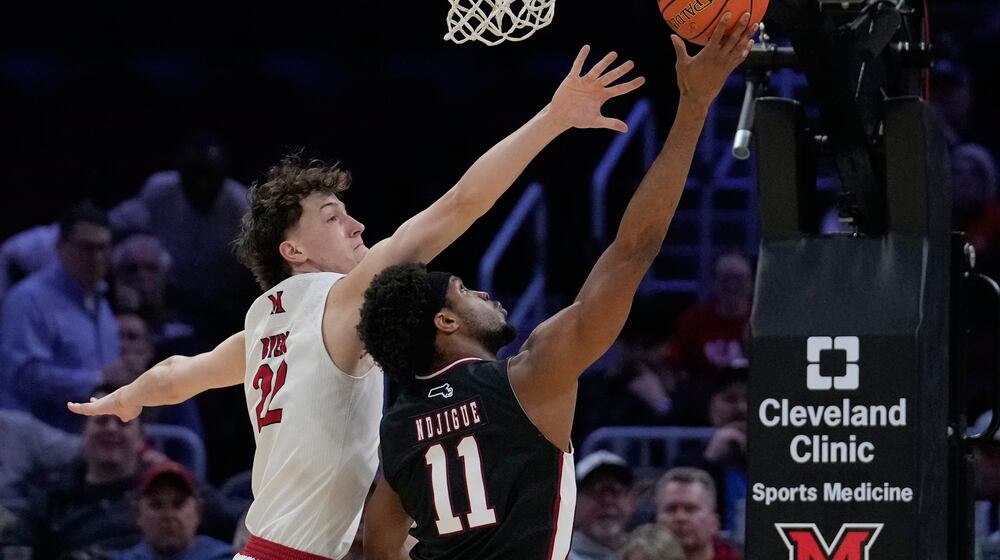 Massachusetts' Jayden Ndjigue (11) shoots as Miami (Ohio) forward Brant Byers (22) defends in the first half of an NCAA college basketball game in the quarterfinals of the Mid-American Conference tournament, Thursday, March 12, 2026, in Cleveland. (AP Photo/Sue Ogrocki)