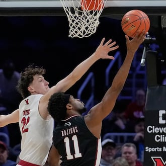 Massachusetts' Jayden Ndjigue (11) shoots as Miami (Ohio) forward Brant Byers (22) defends in the first half of an NCAA college basketball game in the quarterfinals of the Mid-American Conference tournament, Thursday, March 12, 2026, in Cleveland. (AP Photo/Sue Ogrocki)