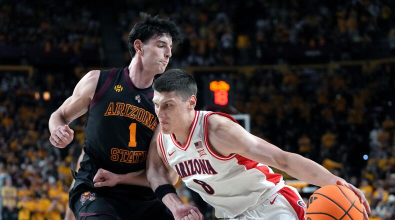 Arizona forward Ivan Kharchenkov (8) drives on Arizona State forward Santiago Trouet during the first half of an NCAA college basketball game, Saturday, Jan. 31, 2026, in Tempe, Ariz. (AP Photo/Rick Scuteri)