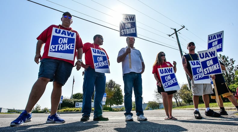 Employees stand near the entrance to the General Motors Service Parts Operations facility on Jacquemin Drive in West Chester Township as they join many United Auto Workers union employees around the country on strike against the automaker Monday, Sept. 16, 2019. NICK GRAHAM/STAFF