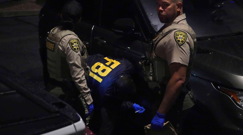 Pima County sheriff and FBI work on a Range Rover in a Culver’s parking lot in Tucson, Ariz. early Saturday, Feb. 14, 2026. (AP Photo/Ty ONeil)
