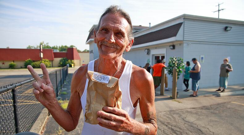 David Blystone, from Springfield, holds up his bag of pot after being the first person in line at The Forest in Springfield Tuesday, Aug. 6, 2024. BILL LACKEY/STAFF