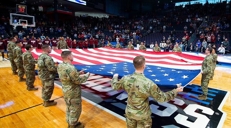 Airmen from Wright-Patterson Air Force Base display a large American flag at midcourt in University of Dayton Arena on March 15 during the singing of the national anthem prior to the first game in the NCAA men’s basketball tournament between Texas Southern and Texas A&M-Corpus Christi. The Air Force was also represented at the event by the Wright-Patterson Honor Guard and an Air Force Band of Flight soloist. U.S. AIR FORCE PHOTO/R.J. ORIEZ