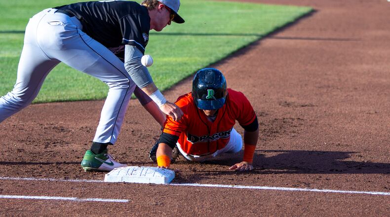 A pickoff attempt bounces off the back of Dayton's Brian Rey in the first inning of Thursday night's game against Lansing at Day Air Ballpark. Rey had singles in his first two at-bats and a sacrifice fly in the fifth for the Dragons' first run. Jeff Gilbert/CONTRIBUTED