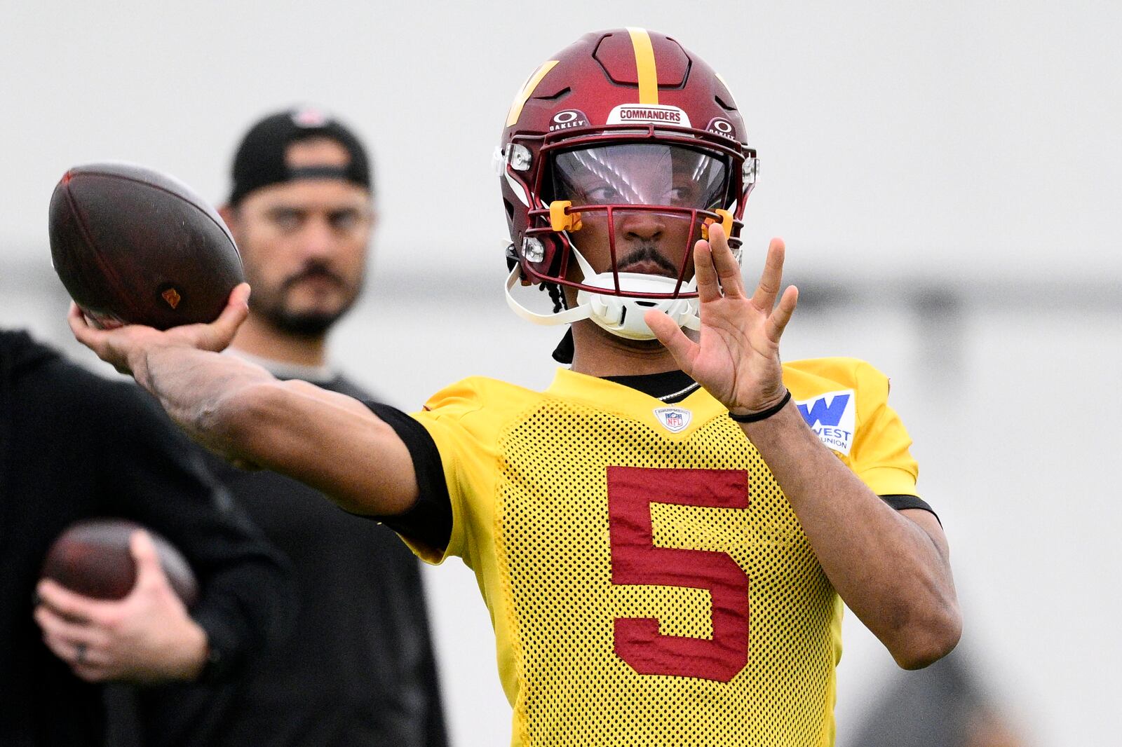 Washington Commanders quarterback Jayden Daniels (5) throws during NFL football practice, Wednesday, May 28, 2025, in Ashburn, Va. (AP Photo/Nick Wass)