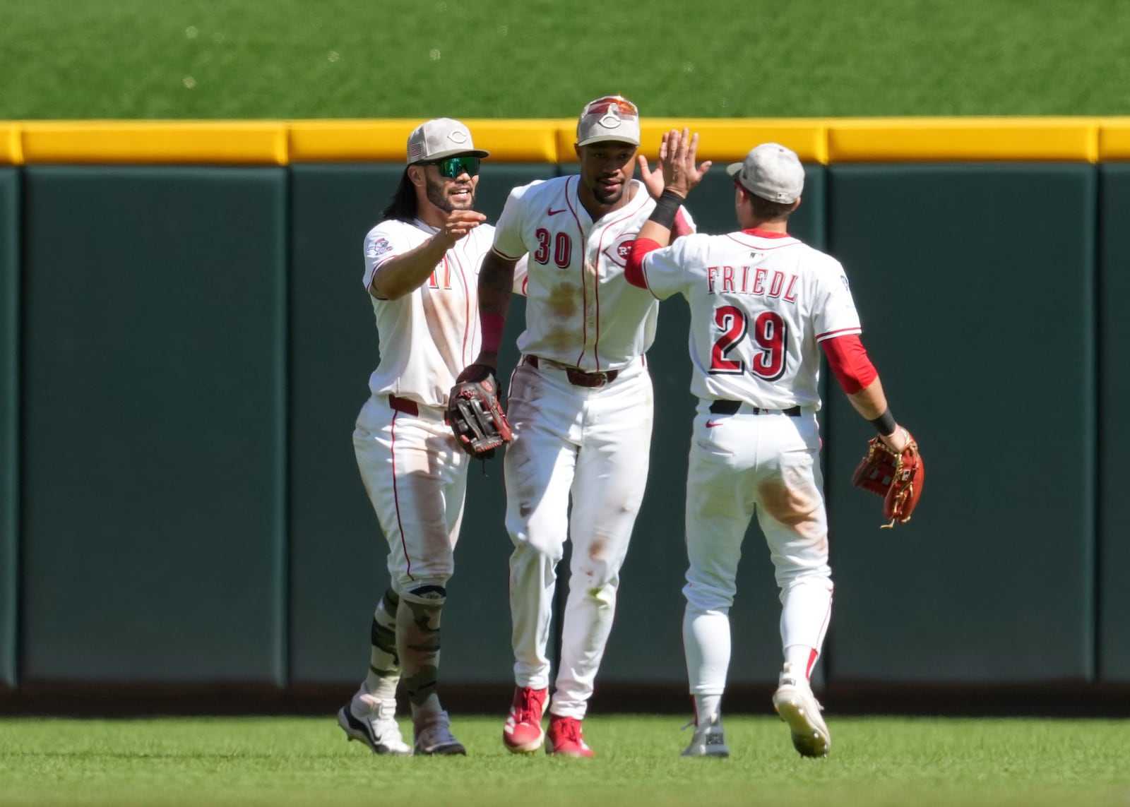 Cincinnati Reds' Will Benson (30) celebrates with teammates Connor Joe (17) and TJ Friedl (29) following a baseball game against the Cleveland Guardians, Sunday, May 18, 2025, in Cincinnati. (AP Photo/Jeff Dean)