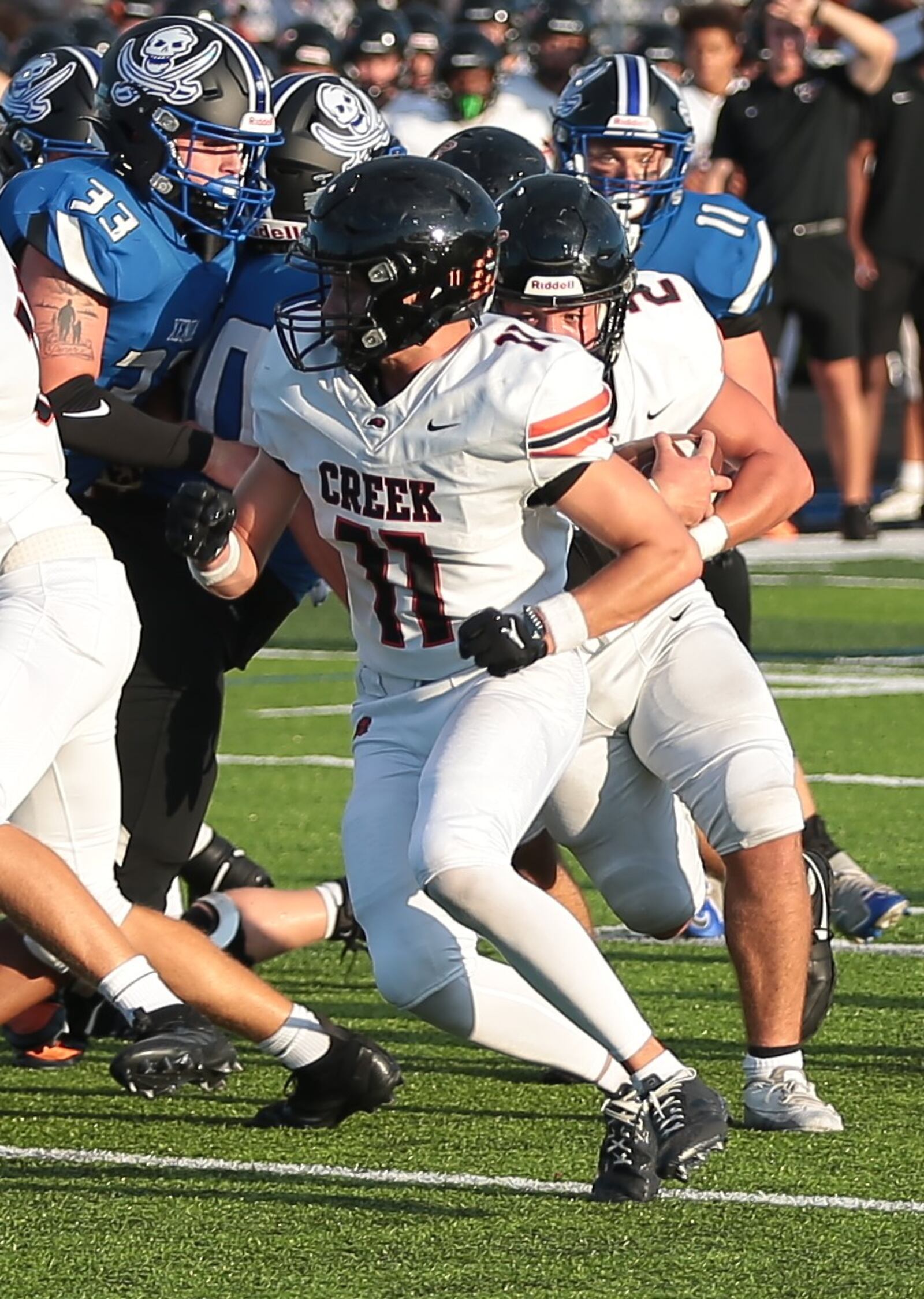 Beavercreek's Kellen Reeves (2) runs the ball as Andrew LeBlanc blocks for him, while Xenia's Cecil Piner (33) and Cameron Ashley (11) pursue during a game Friday, Aug. 22, 2025, at Doug Adams Stadium in Xenia. Steve Black / Staff