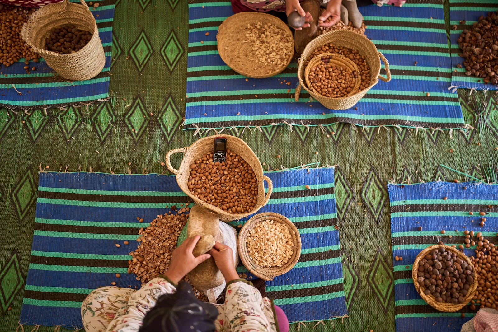 Women crack argan nuts at a cooperative that extracts and produces argan oil and products, in Essaouira, Morocco, Thursday, May 22, 2025. (AP Photo/Mosa'ab Elshamy)