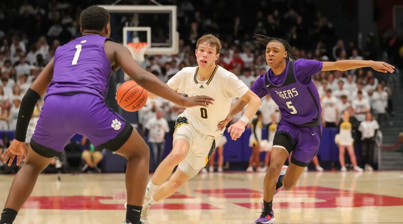 Centerville High School senior Gabe Cupps drives through Pickerington Central's Markell Johnson and Juwan Turner (1) during a Division I state semifinal game on Saturday evening at University of Dayton Arena. CONTRIBUTED PHOTO BY MICHAEL COOPER