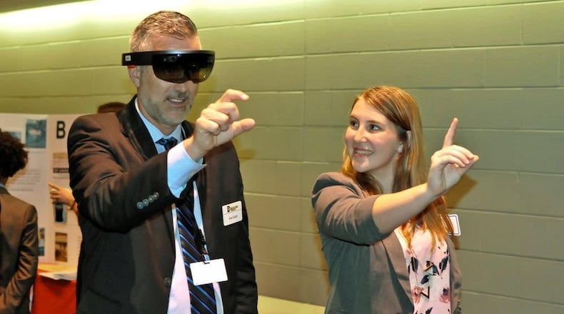 Butler Tech Superintendent Jon Graft gets a demonstration of a new app for learning visors invented by Ross High School students. Among the inventors is sophomore Isabella Saylor, who recently guided Graft through the visor’s “mixed reality” demonstration.