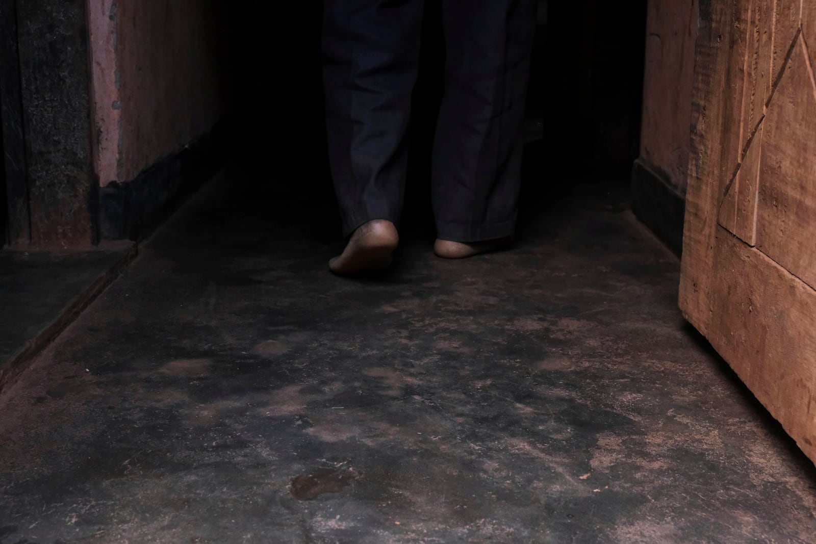 Simon Tigawalana walks into his house with some clay-based earthen floors by EarthEnable on May 16, 2025, in Jinja, Uganda. (AP Photo/Hajarah Nalwadda)