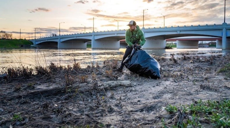 Nathan Kessler cleans up trash along the Great Miami River in Dayton. CONTRIBUTED
