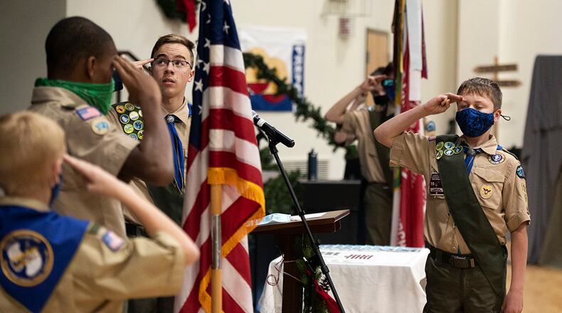 Boy Scout Troop 162 members salute the flag during the opening ceremony of a monthly court of honor Dec. 13 in Fairborn. In addition to the usual awarding of merit badges and advancement in scout ranks, the gathering marked the 75th anniversary of the outfit, which began as the Wright-Patterson Air Force Base troop. U.S. AIR FORCE PHOTO/R.J. ORIEZ