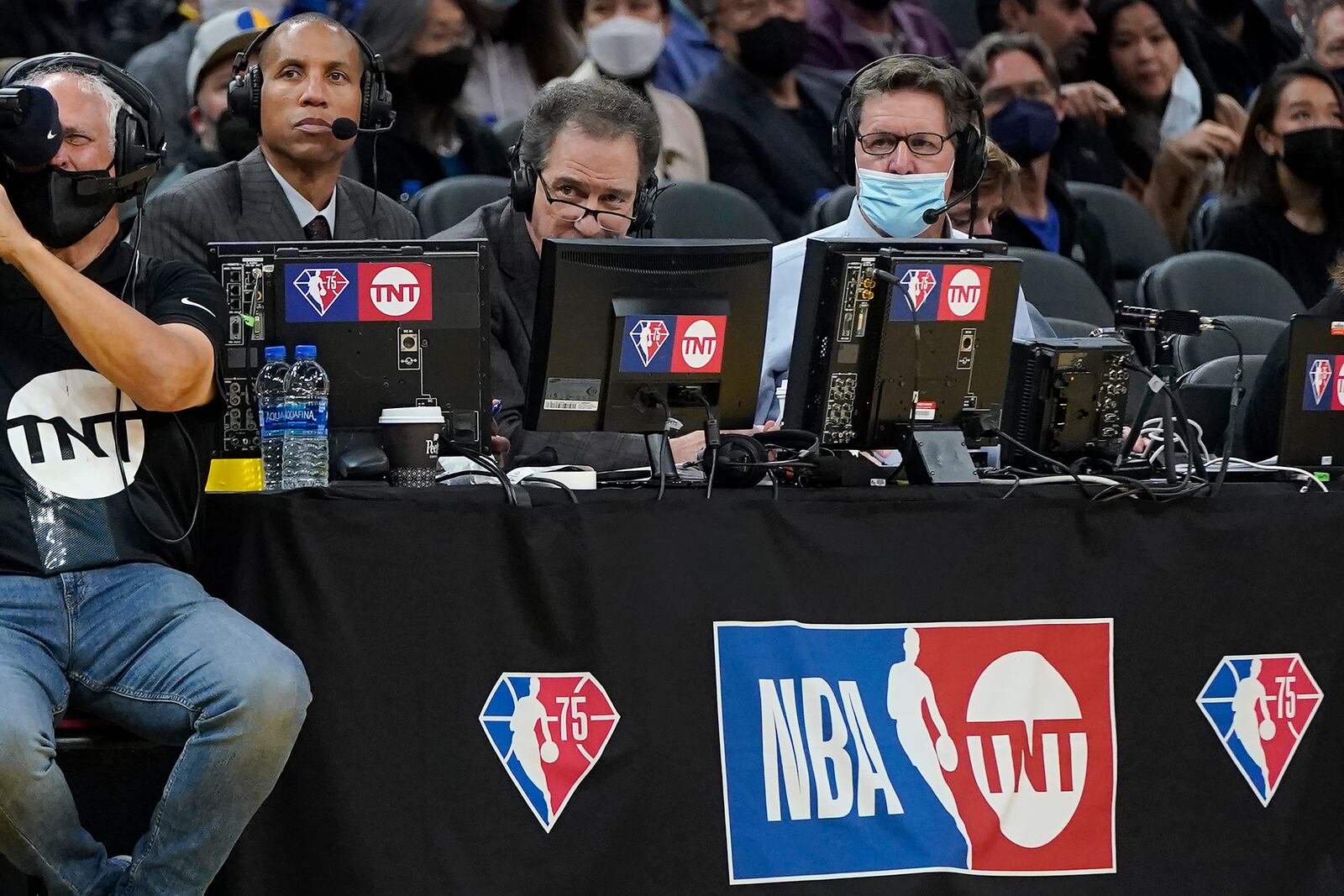 FILE - Broadcasters Reggie Miller, left, and Kevin Harlan, middle, during an NBA basketball game between the Golden State Warriors and the Minnesota Timberwolves in San Francisco, Jan. 27, 2022. (AP Photo/Jeff Chiu, Filer)