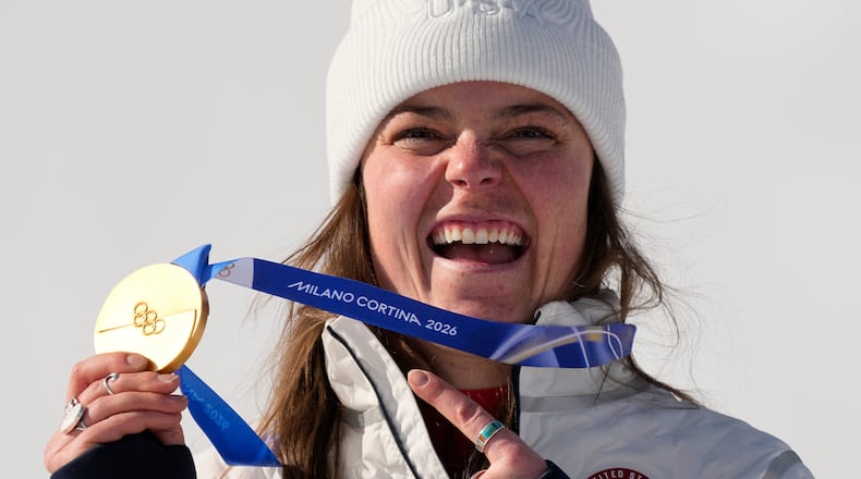 United States' Breezy Johnson shows her gold medal in the alpine ski women's downhill race, at the 2026 Winter Olympics, in Cortina d'Ampezzo, Italy, Sunday, Feb. 8, 2026. (AP Photo/Andy Wong)