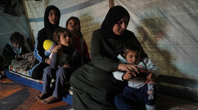 Rotana al-Regeb, who was allowed into Gaza from Egypt following the long-awaited reopening of the Rafah border crossing, reunites with her children in Khan Younis, southern Gaza Strip, Tuesday, Feb. 3, 2026. (AP Photo/Jehad Alshrafi)