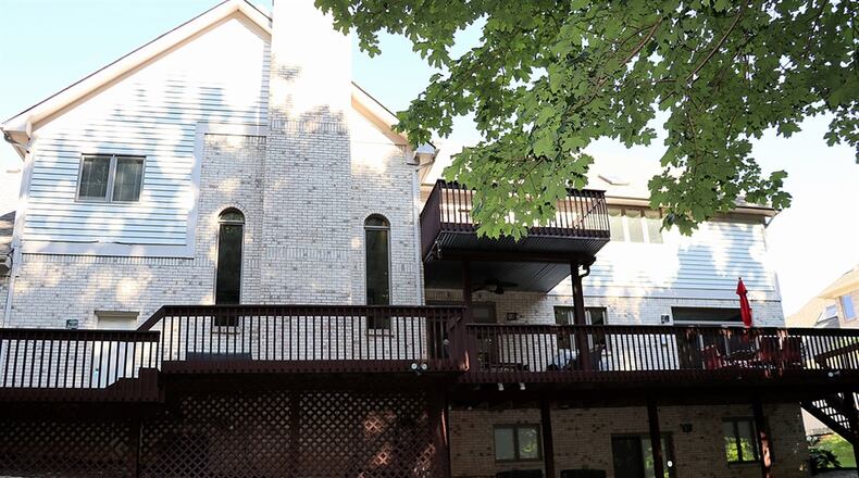 A large balcony deck overlooks the back yard; a smaller balcony deck is accessible from one of the second-floor bedrooms.