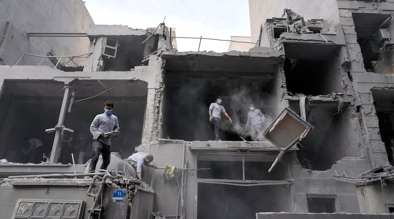 Volunteers clean debris from a residential building damaged when a nearby police station was hit Friday in a U.S.-Israeli strike in Tehran, Iran, Sunday, March 15, 2026. (AP Photo/Vahid Salemi)