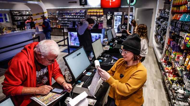 Ohioan Dean Dearth, left, buys recreational marijuana from the Amazing Budz store in Adrian Michigan, just across the Ohio border earlier this fall. On Nov. 7, Ohioans voted to legalize recreational marijuana use here. JIM NOELKER/STAFF