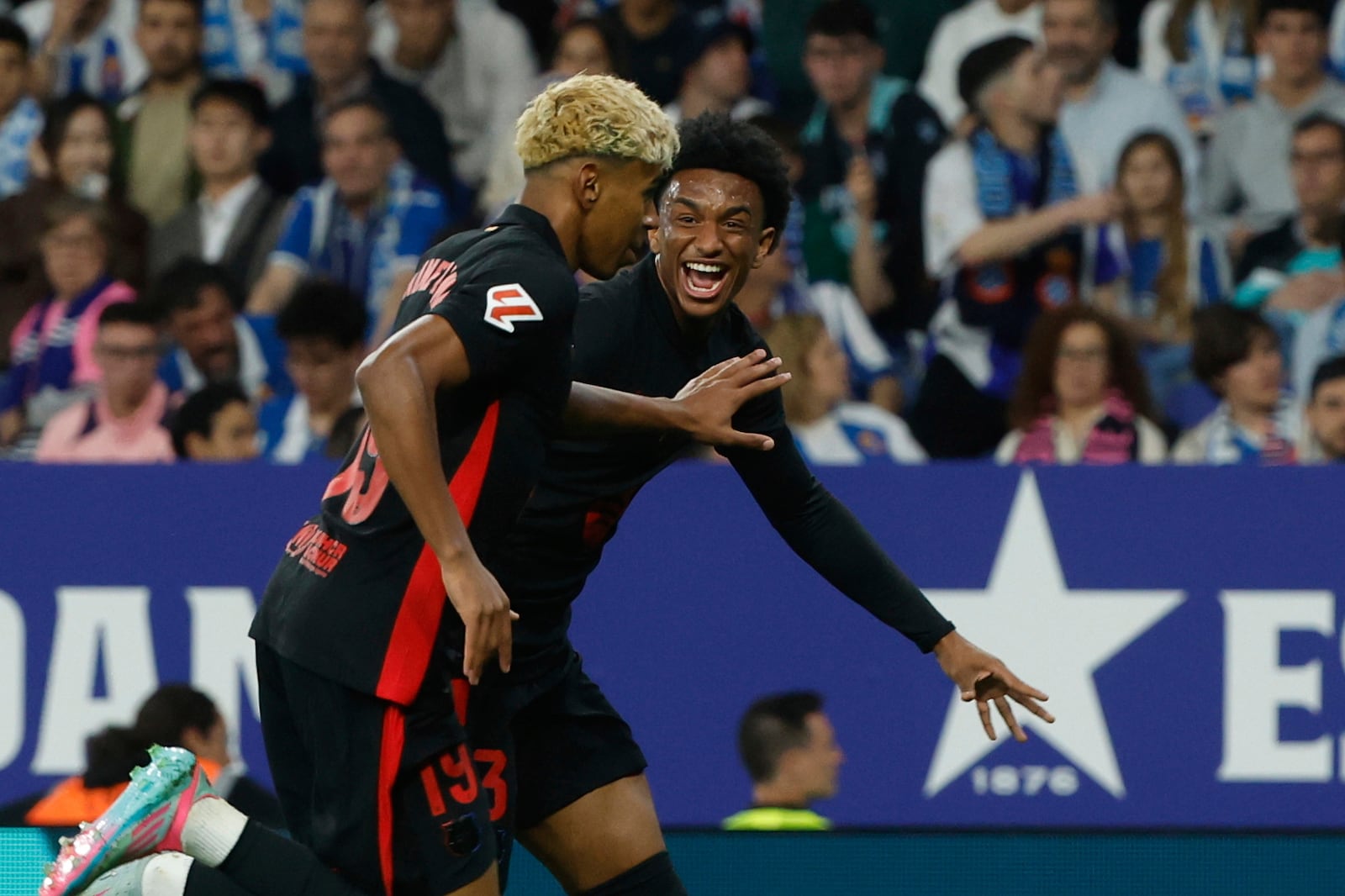 Barcelona's Lamine Yamal, left, celebrates with his teammate Alejandro Balde after scoring his side's opening goal during a Spanish La Liga soccer match between Barcelona and Espanyol at Lluis Companys Olympic Stadium in Barcelona, Spain, Thursday, May 15, 2025. (AP Photo/Joan Monfort)