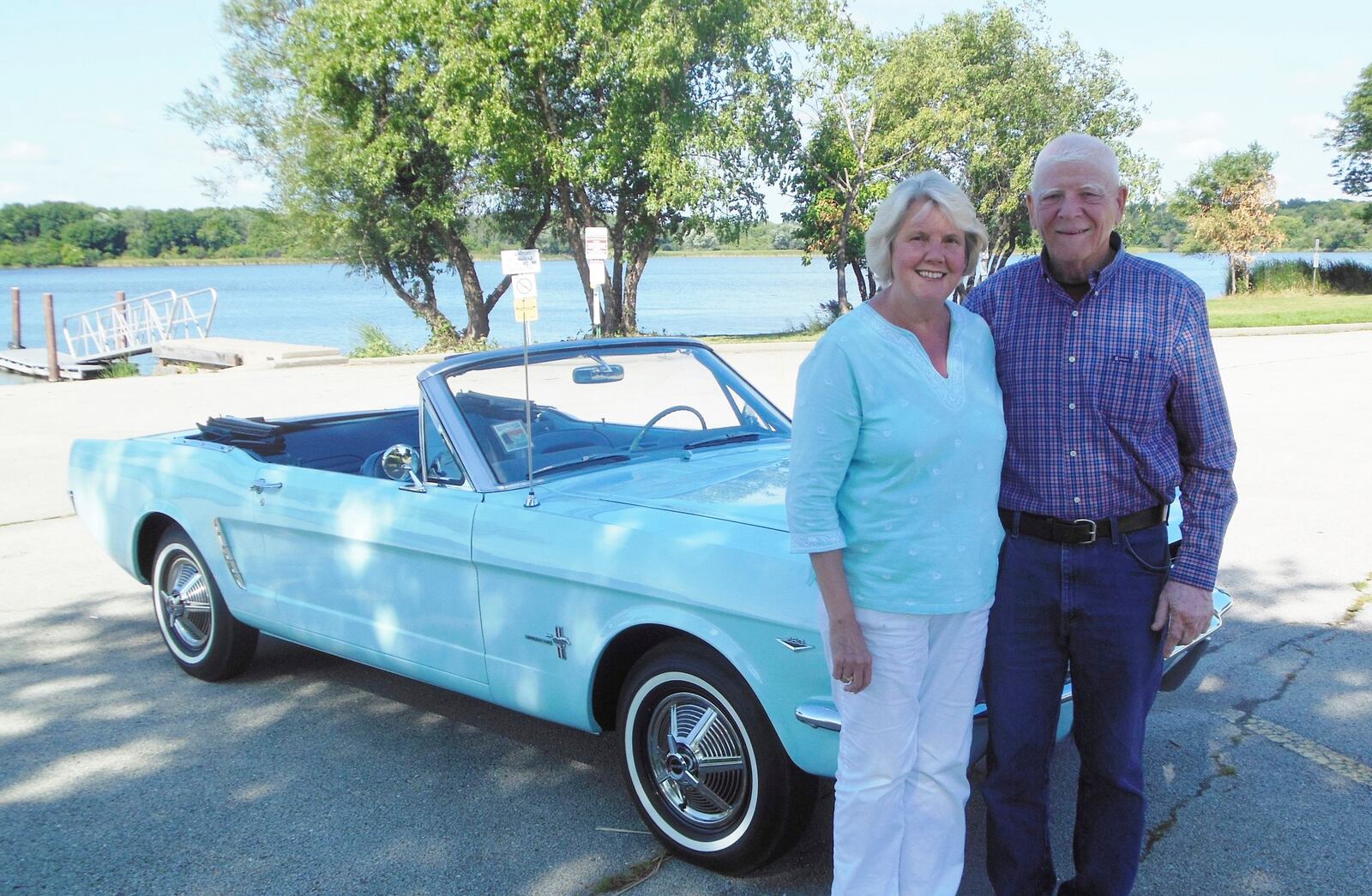 Gail (L) and Tom Wise pose with her Skylight Blue 1964 1/2 Ford Mustang convertible in Chicago, Illinois August 13, 2013. Gail Wise, then using her maiden name of Gail Brown, made the first known retail purchase of a Mustang on April 15, 1964, two days before the model went on sale. Ford will unveil its next-generation 2015 Mustang on December 5 for the model's 50th anniversary with simultaneous events in Michigan, Shanghai, Sydney, Barcelona, New York and Los Angeles. Picture taken August 13, 2013. REUTERS/Courtesy of Tom and Gail Wise/Handout via Reuters