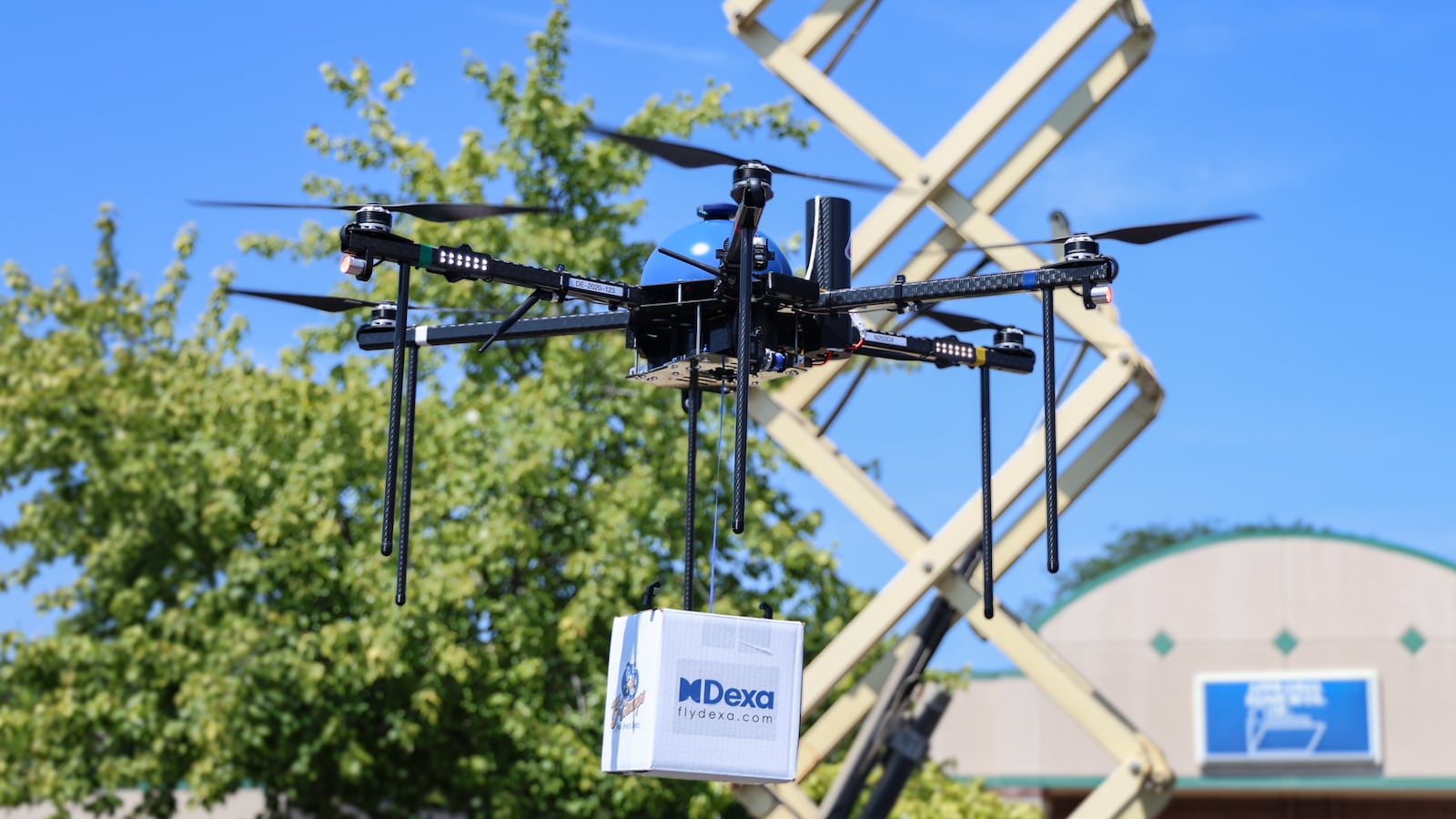 A drone operated by DEXA drops a test delivery during a demonstration on Wednesday, July 23 at TJ Chumps in Kettering. BRYANT BILLING / STAFF