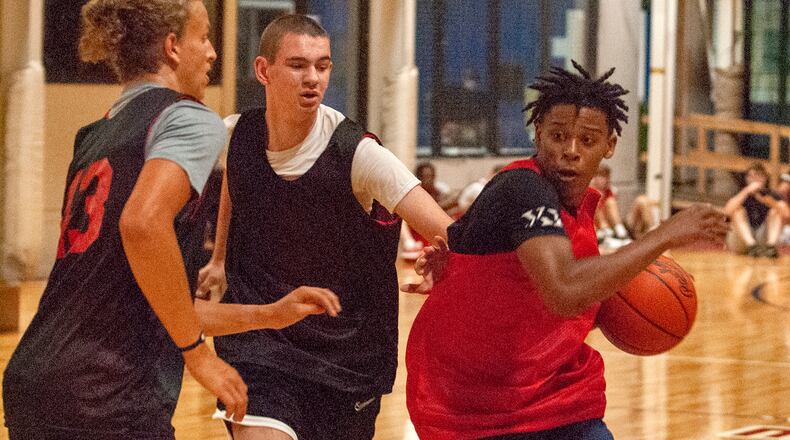 Thrugood Marshall senior Anthony McComb drives against Alter junior Jacob Conner (center) and Springboro junior Sam Feldman during Wednesday night's Dayton Elite Open Gym at the Dayton Sports Complex. Jeff Gilbert/CONTRIBUTED