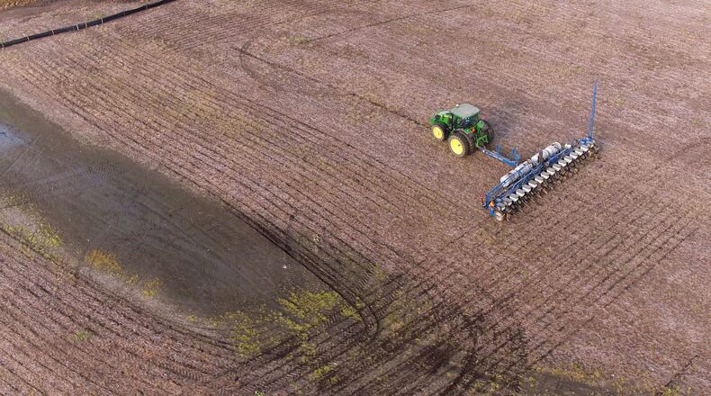 A farmer in Beavercreek avoids a wet area in the field near Shakertown Road. Short dry spells between rainy days have farmers scrambling to get corn and soybeans planted. Once past May 15, farmers begin losing an average bushel of corn per acre each day according to Sam Custer, Darke County Ohio State Extension educator. As trade concerns with China continue and the price of a bushel of soybeans remains at about half what farmers were making in September 2012, area farms are adding moist fields to the list of factors that could effect their futures. TY GREENLEES / STAFF