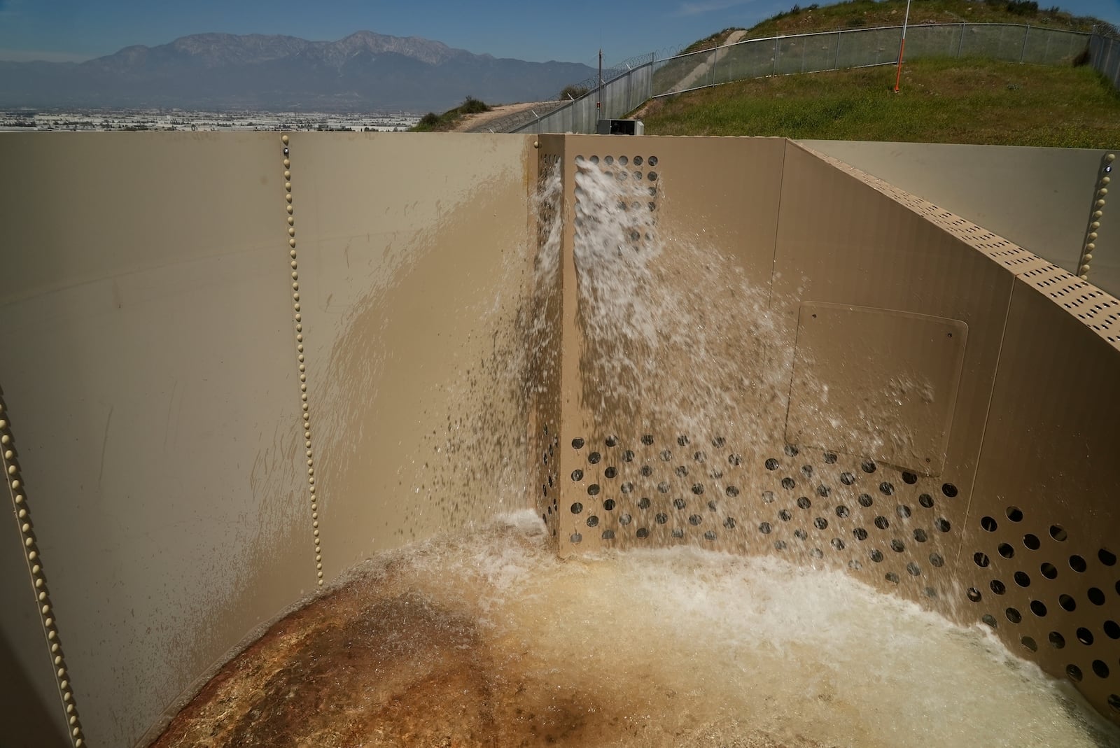 A Heli-Hydrant, a small, open tank that helicopters can rely on to get water faster for urban fires, fills with water during a demonstration Thursday, April 10, 2025, in Jurupa Valley, Calif. (AP Photo/Brittany Peterson)