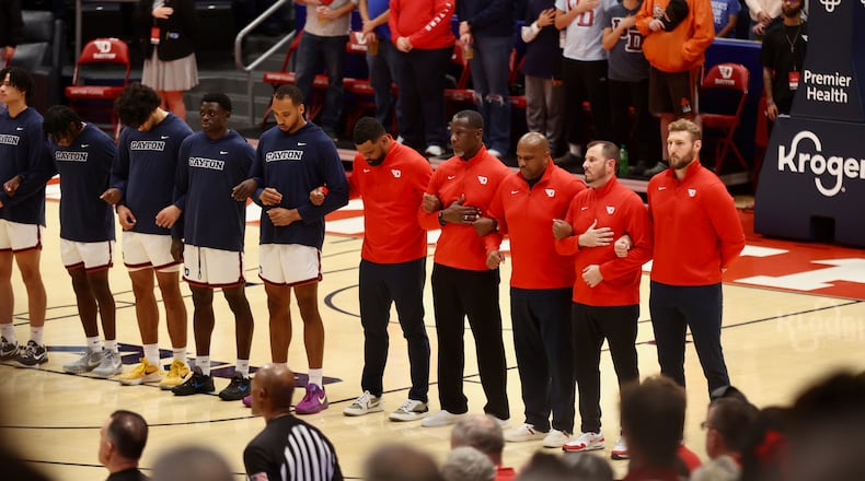 Dayton coaches and players stand for the national anthem before a game against Capital on Saturday, Nov. 16, 2024, at UD Arena. David Jablonski/Staff