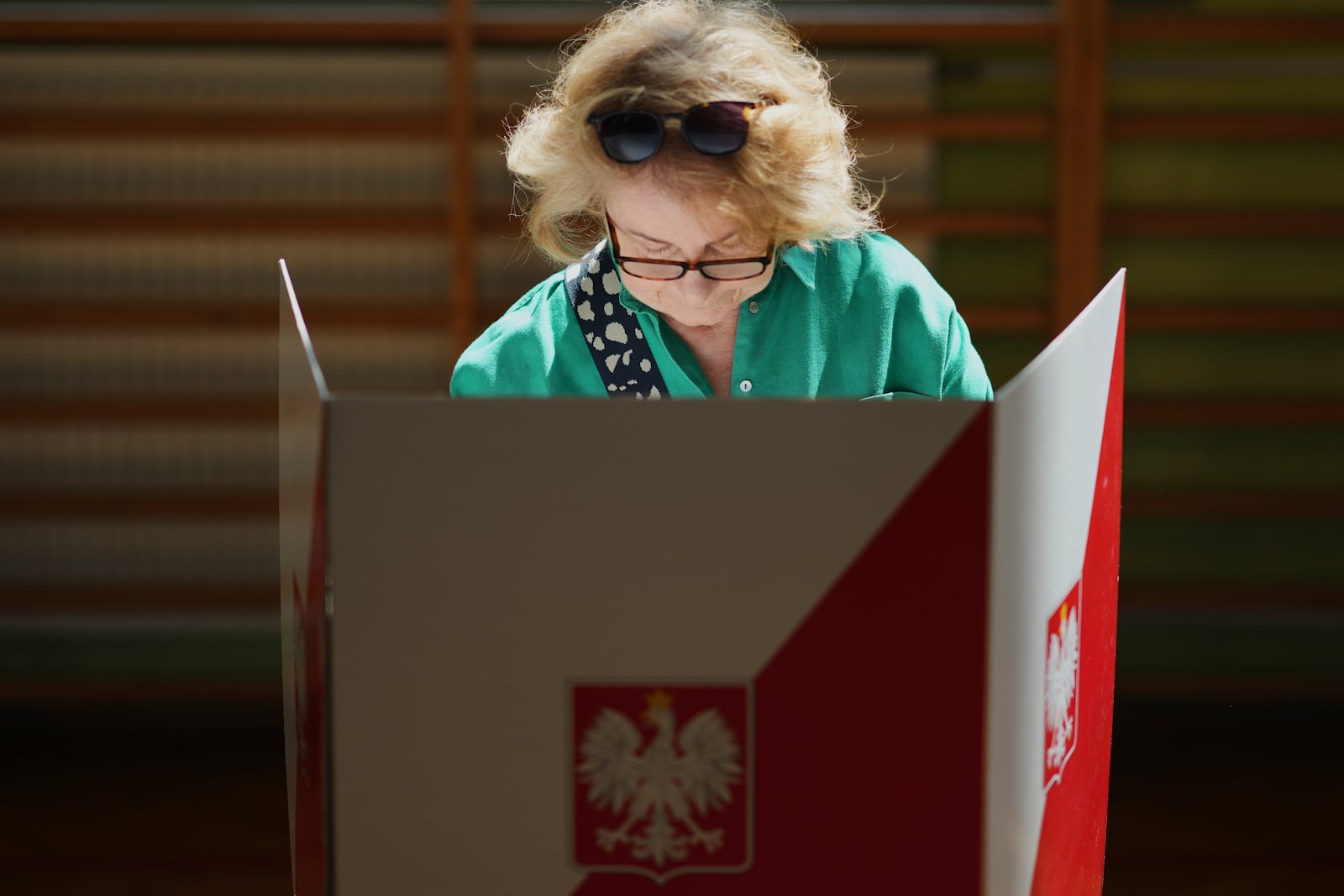 A women prepares to cast her vote during the presidential election runoff in Warsaw, Poland, Sunday, June 1, 2025. (AP Photo/Petr David Josek)