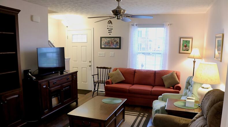 Wood plank flooring fills the entry and continues into the living room and adjoining dining room. A front window allows for natural light into the living room.