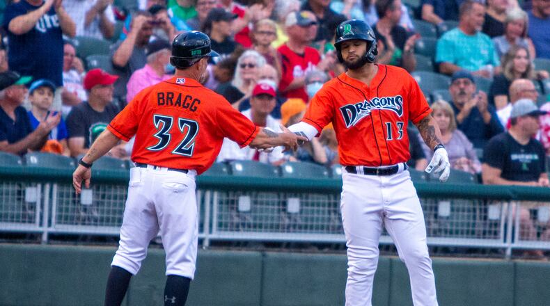 Dragons third baseman Juan Martinez is greeted by third base coach Darren Bragg after hitting a two-run triple in the third inning Friday night at Day Air Ballpark. Jeff Gilbert/CONTRIBUTED
