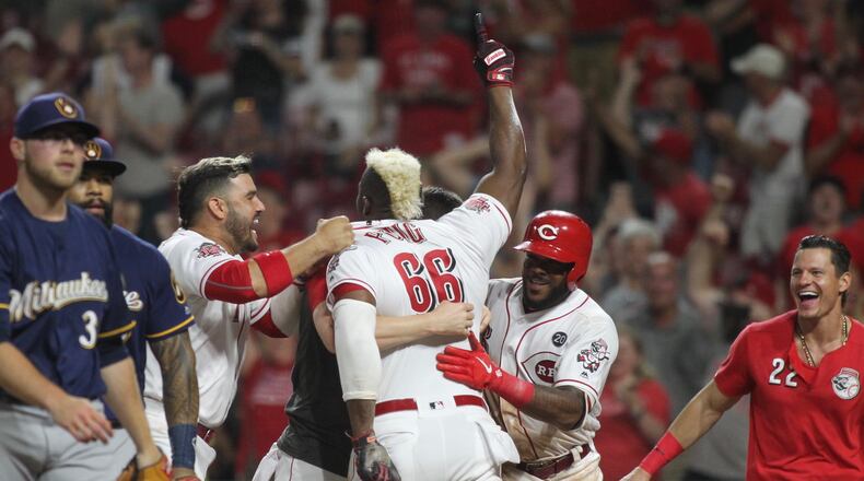 The Reds celebrate after Yasiel Puig scored the winning run against the Brewers on July 2, 2019, at Great American Ball Park in Cincinnati.