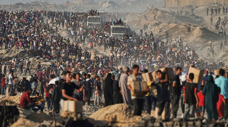 FILE - People carry sacks and boxes of food and humanitarian aid that was unloaded from a World Food Program convoy that had been heading to Gaza City in the northern Gaza Strip, June 16, 2025. (AP Photo/Jehad Alshrafi, File)