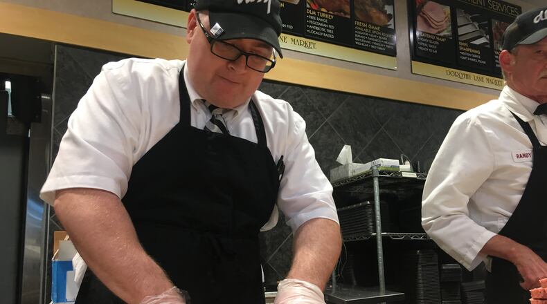 Joe Neuhauser, general manager of the meat department at Dorothy Lane Market in Oakwood, cuts a slab of meat before Memorial Day weekend. KARA DRISCOLL/STAFF