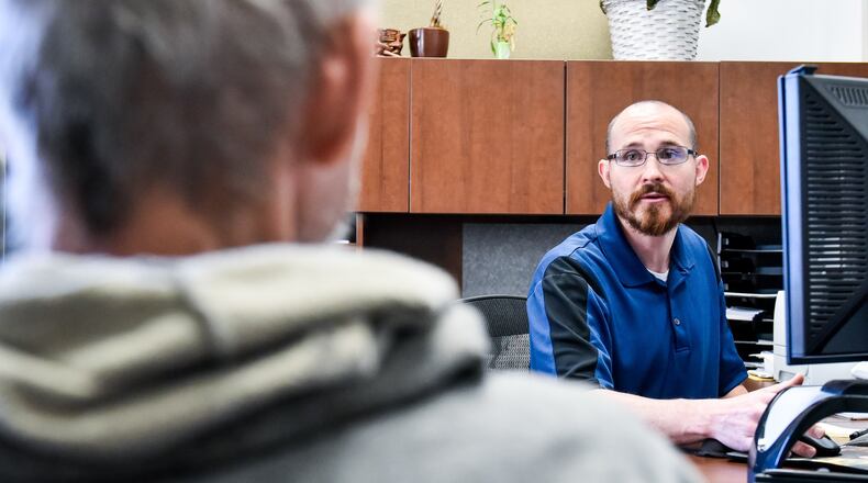 Chief Service Officer Matt Jones, right, helps Franklin English, a Navy veteran, with services during a meeting at Butler County Veterans Service Commission Thursday, May 16, 2019 in Hamilton. NICK GRAHAM/STAFF