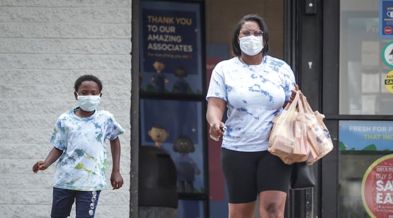 Lashandra Carey and her son Princeton Flagg carry groceries out of the Krogers on Wayne Ave. Thursday afternoon July 9, 2020.