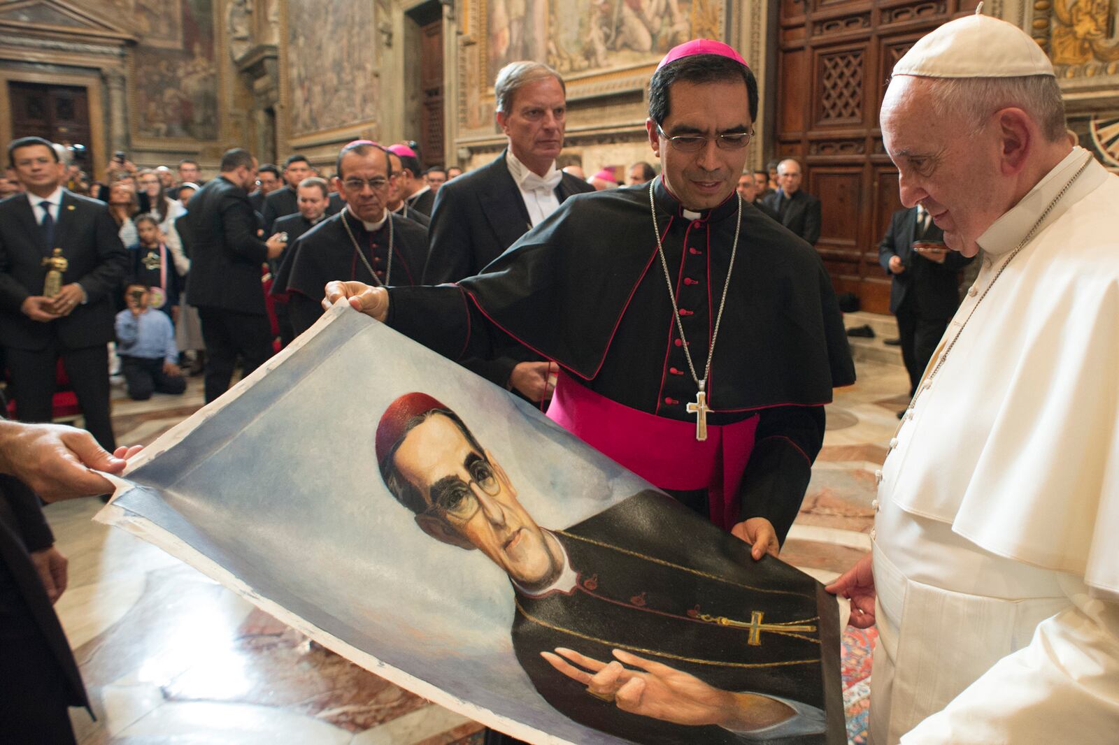 FILE - Pope Francis is presented with an image of Roman Catholic Archbishop Oscar Romero during a private audience granted to participants to the pilgrimage from El Salvador at the Vatican, Tuesday, Oct. 20, 2015. (L'Osservatore Romano/Pool Photo via AP, file)